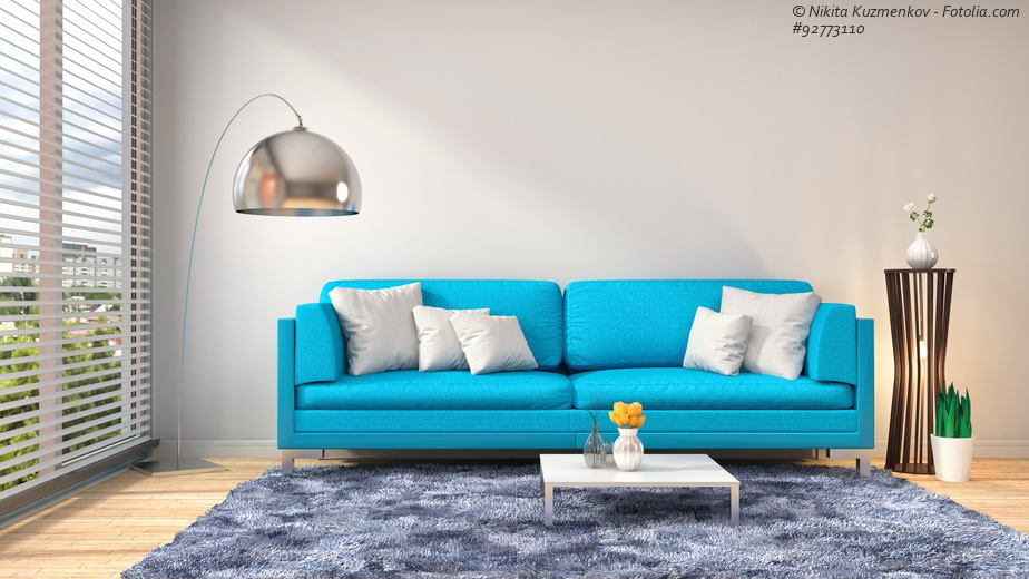 Sofa Türkis mit weißen Kissen und Stehlampe aus Metall