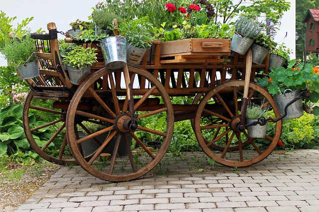Gartengestaltung: Kutsche aus Holz mit Blumen